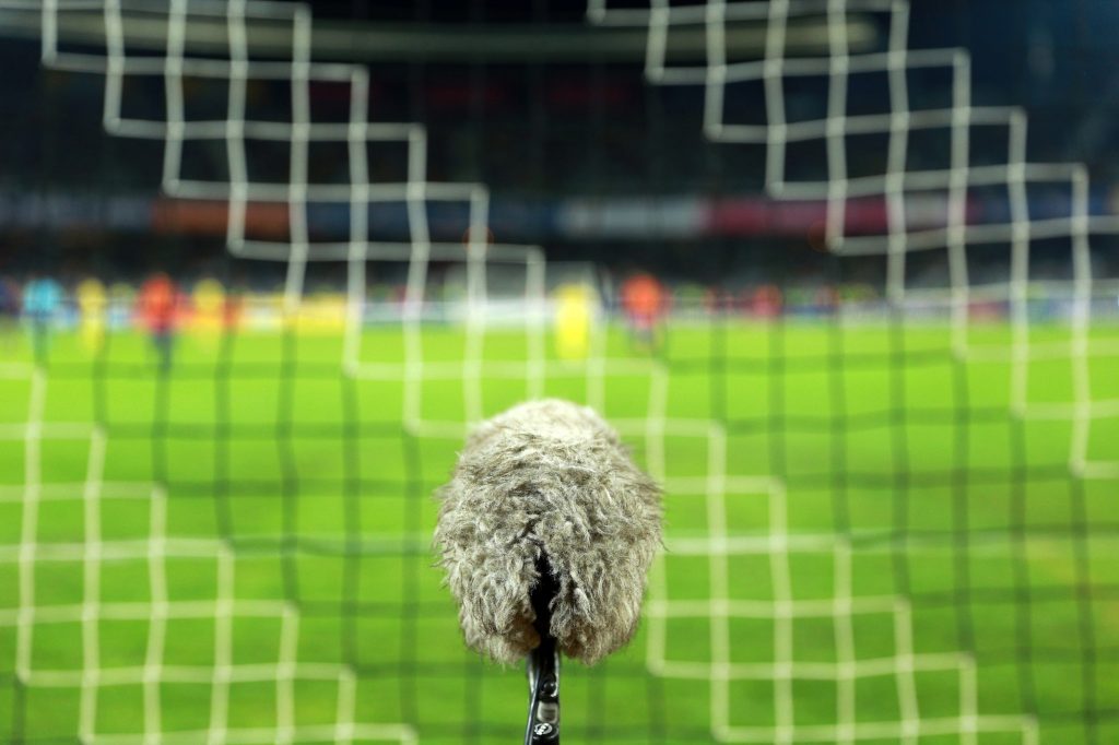 Big and furry sport microphone on a soccer field behind the goal net