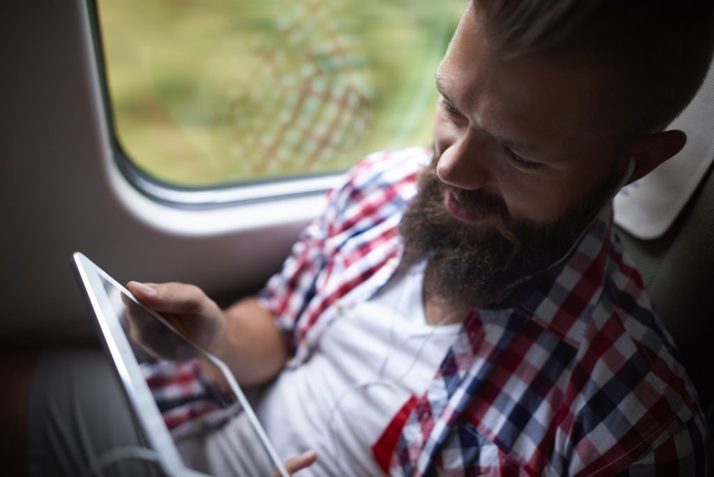 Man using the digital tablet during the travel