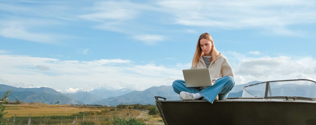 Remote work.Girl freelancer works remotely on the sea shore. workation, remote work,WFVH,Van Life vi