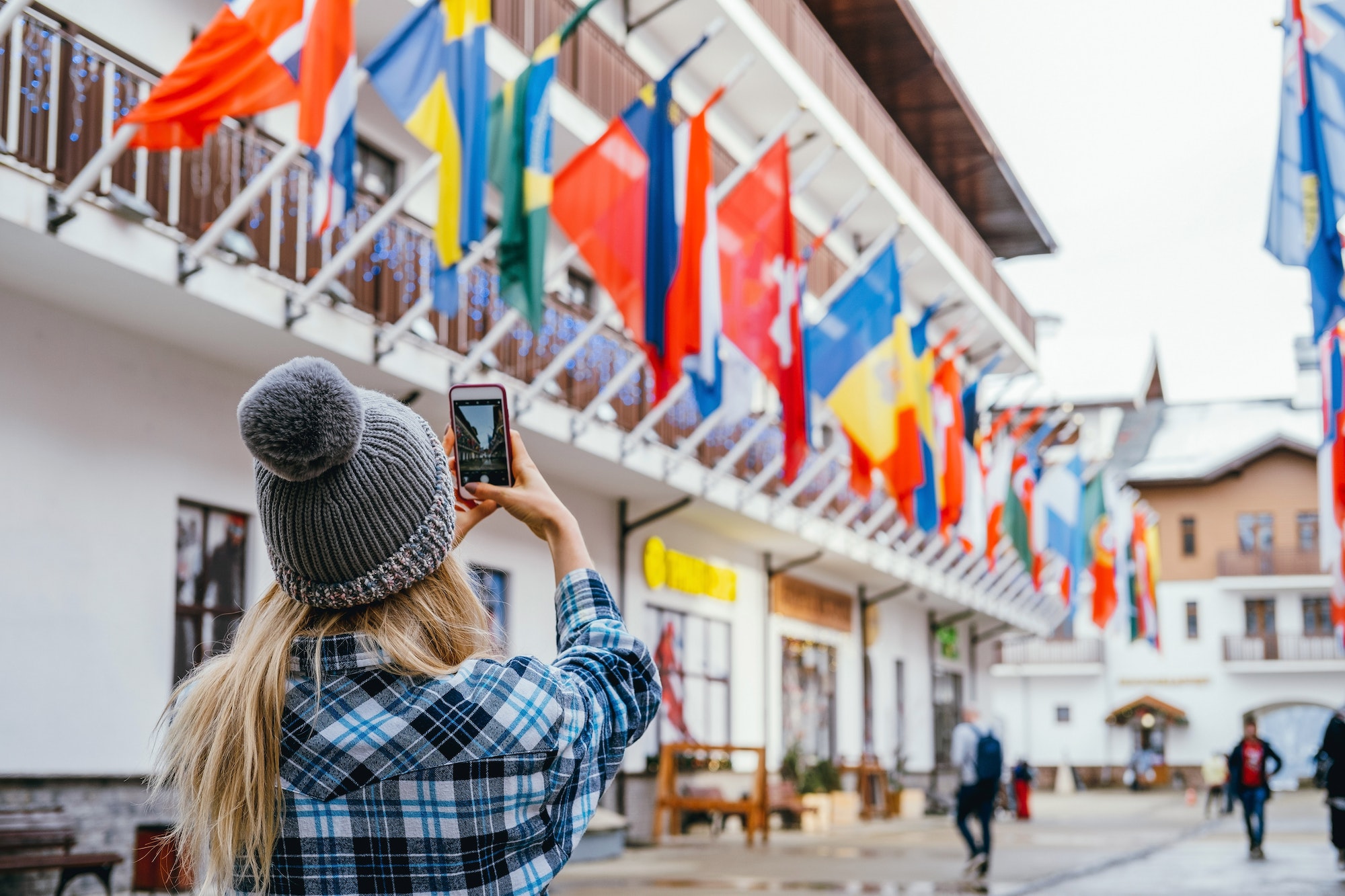 Young woman taking pictures in European travel. Solo travel and using technology concept.
